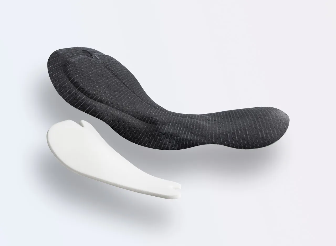 Two sports pads in different colors, one in black with a textured design and the other in white with a simple shape.