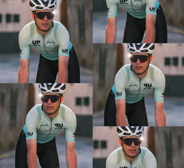 A cyclist wearing a custom light blue jersey with the 'UP cycling' and 'owayo' logo on the chest, riding on a street.